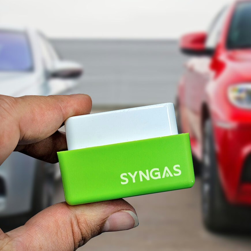 Image officielle : le petit boîtier SynGas tenu en main devant une voiture